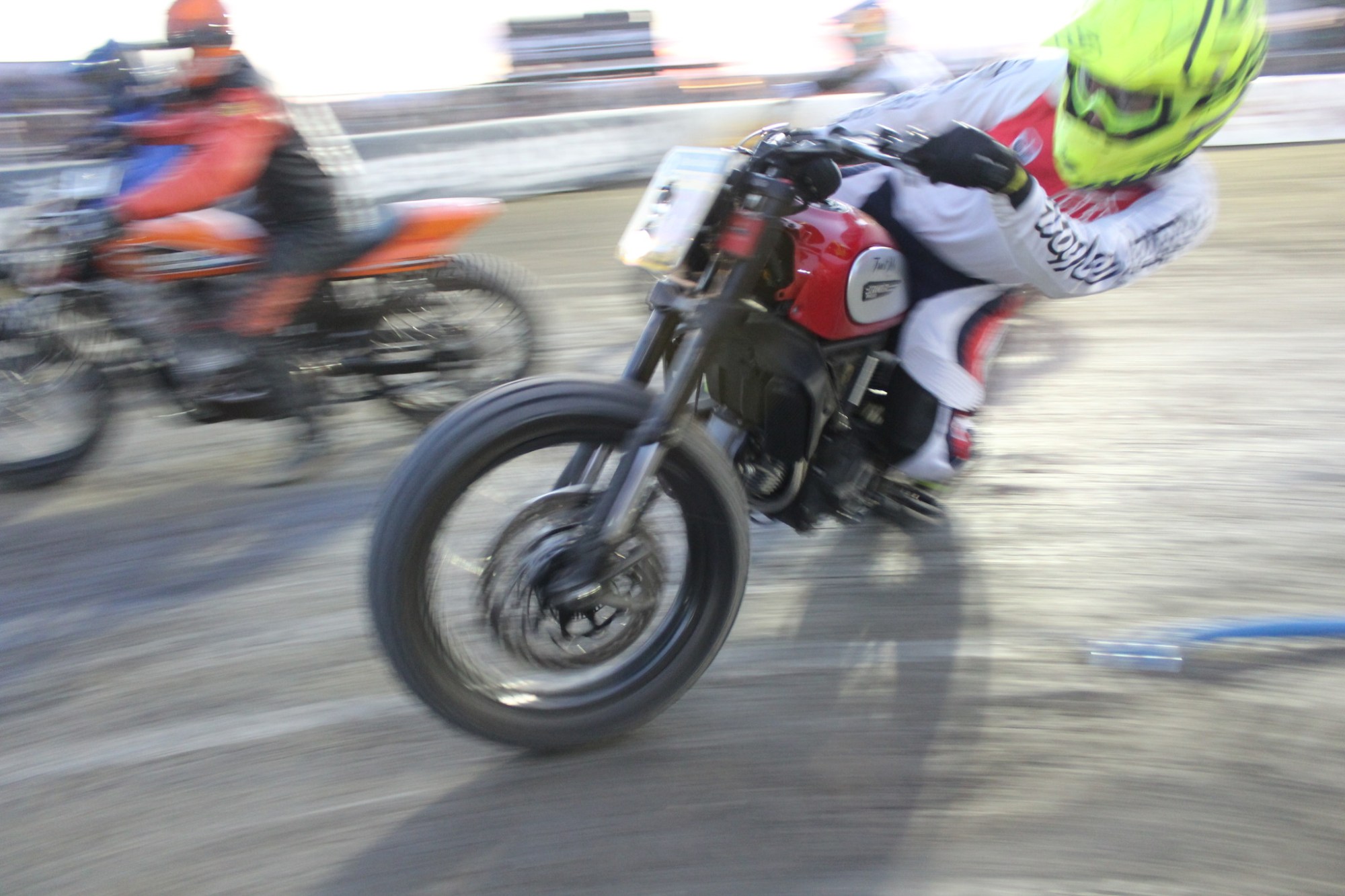 A Ducati motorcycle flat track hooligan racer negotiates a turn on a race track.