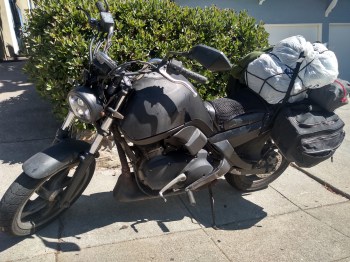 a black motorcycle loaded with luggage small buell blast