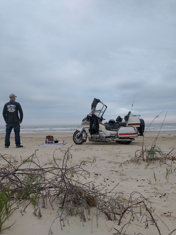 person standing beach horizon ocean with motorcycle sidecar landscape