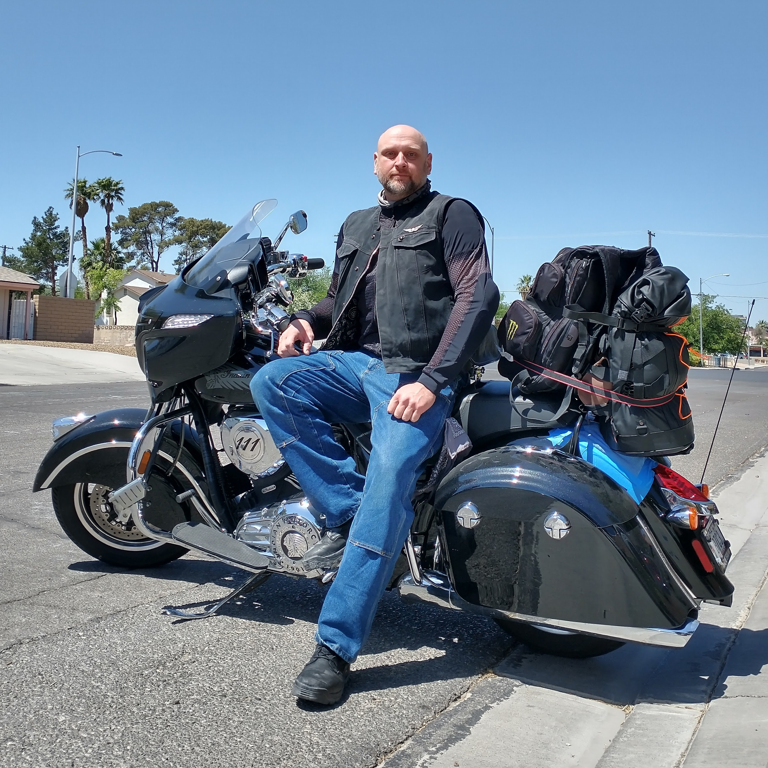 biker stands with motorcycle on road