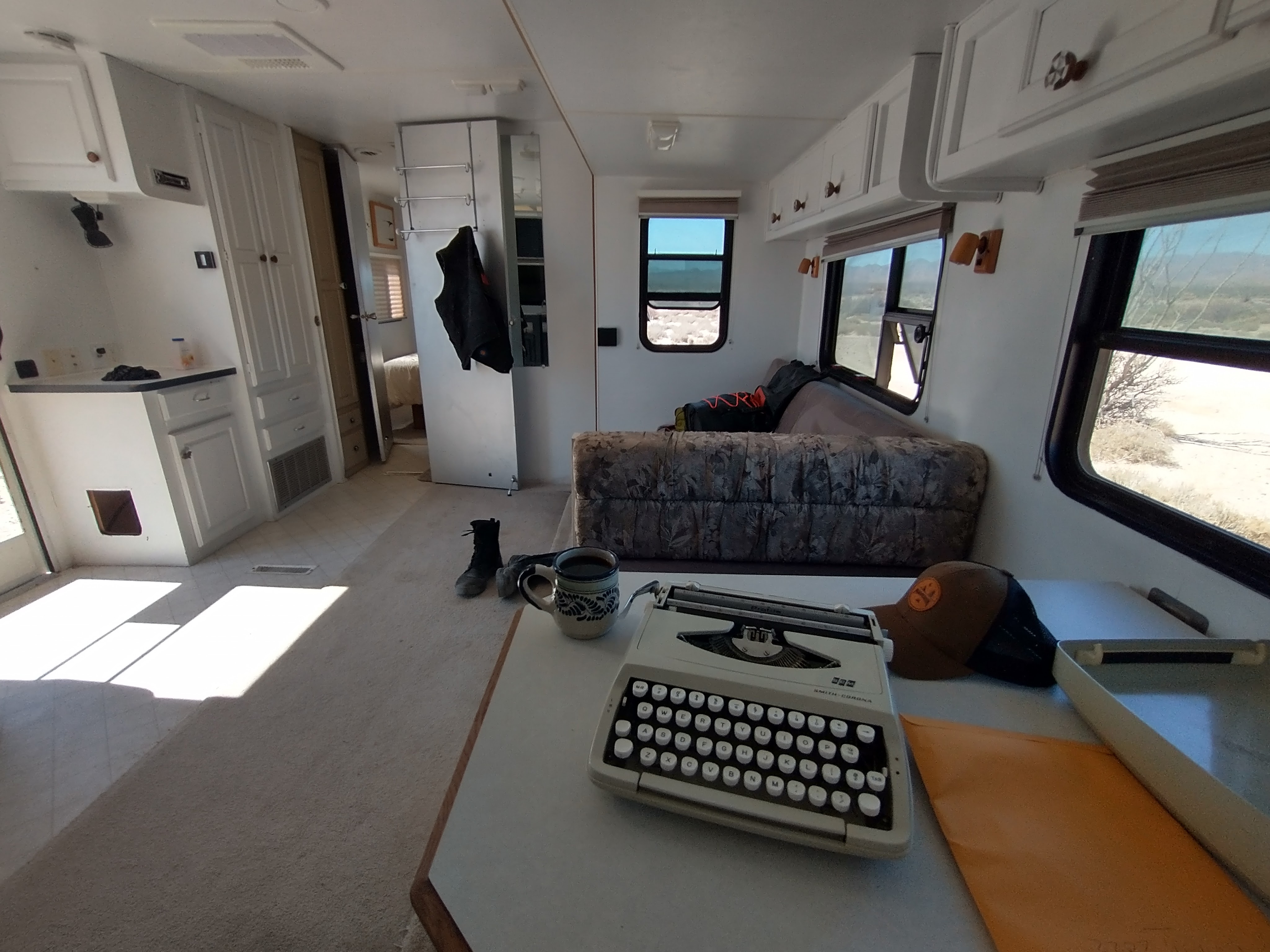 typewriter sitting on desk in travel trailer with coffee