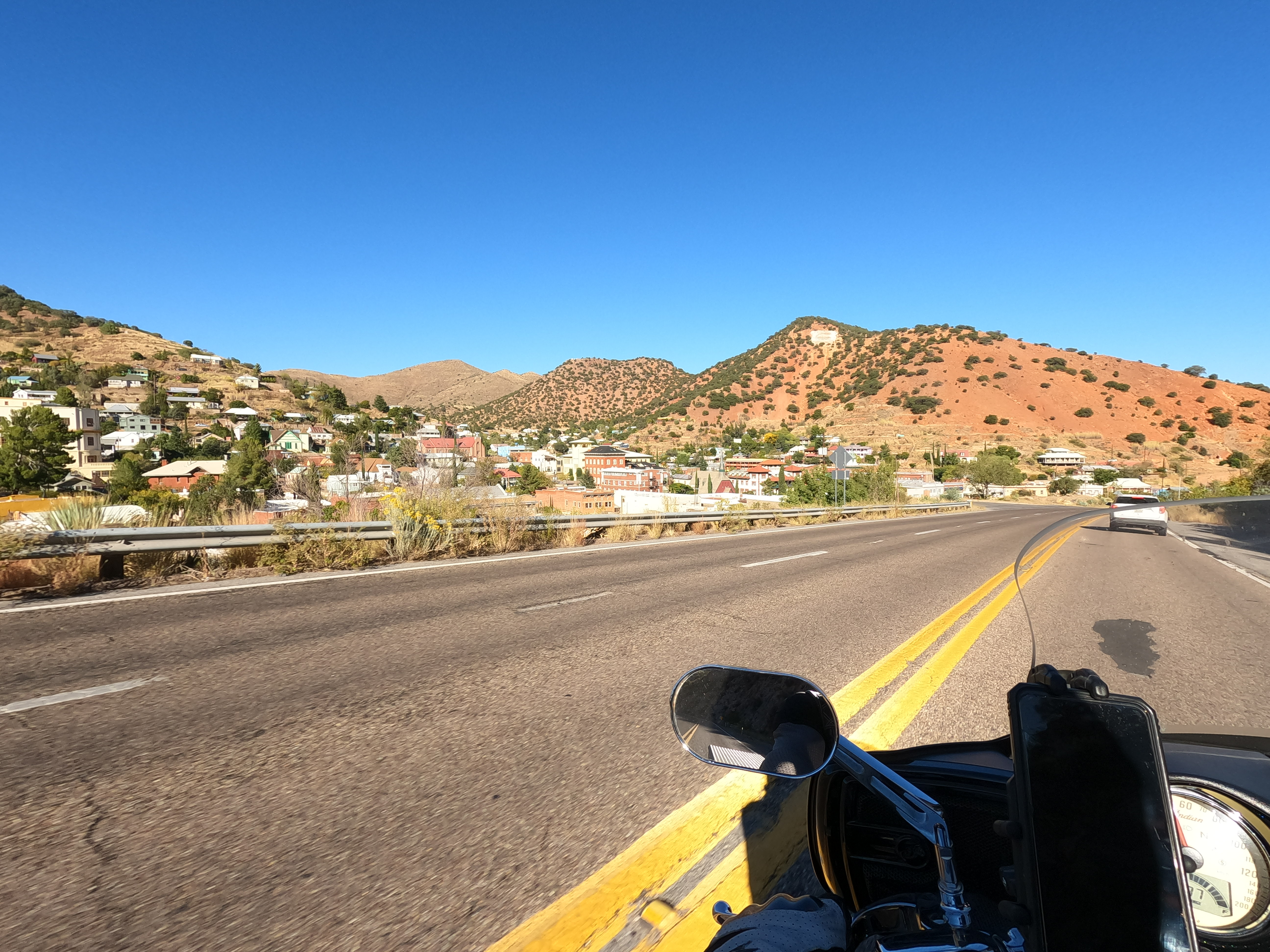 View from a motorcycle of Tombstone Canyon, where Bisbee Arizona is located. The Mule mountains are in the background in red-brown with scarce foilage