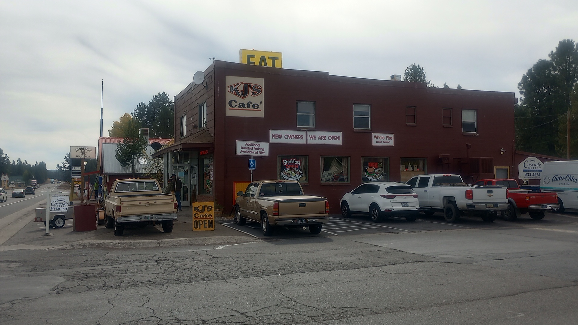 KJ Cafe in Chemult Oregon. Brick two story building with cars nd trucks parked around