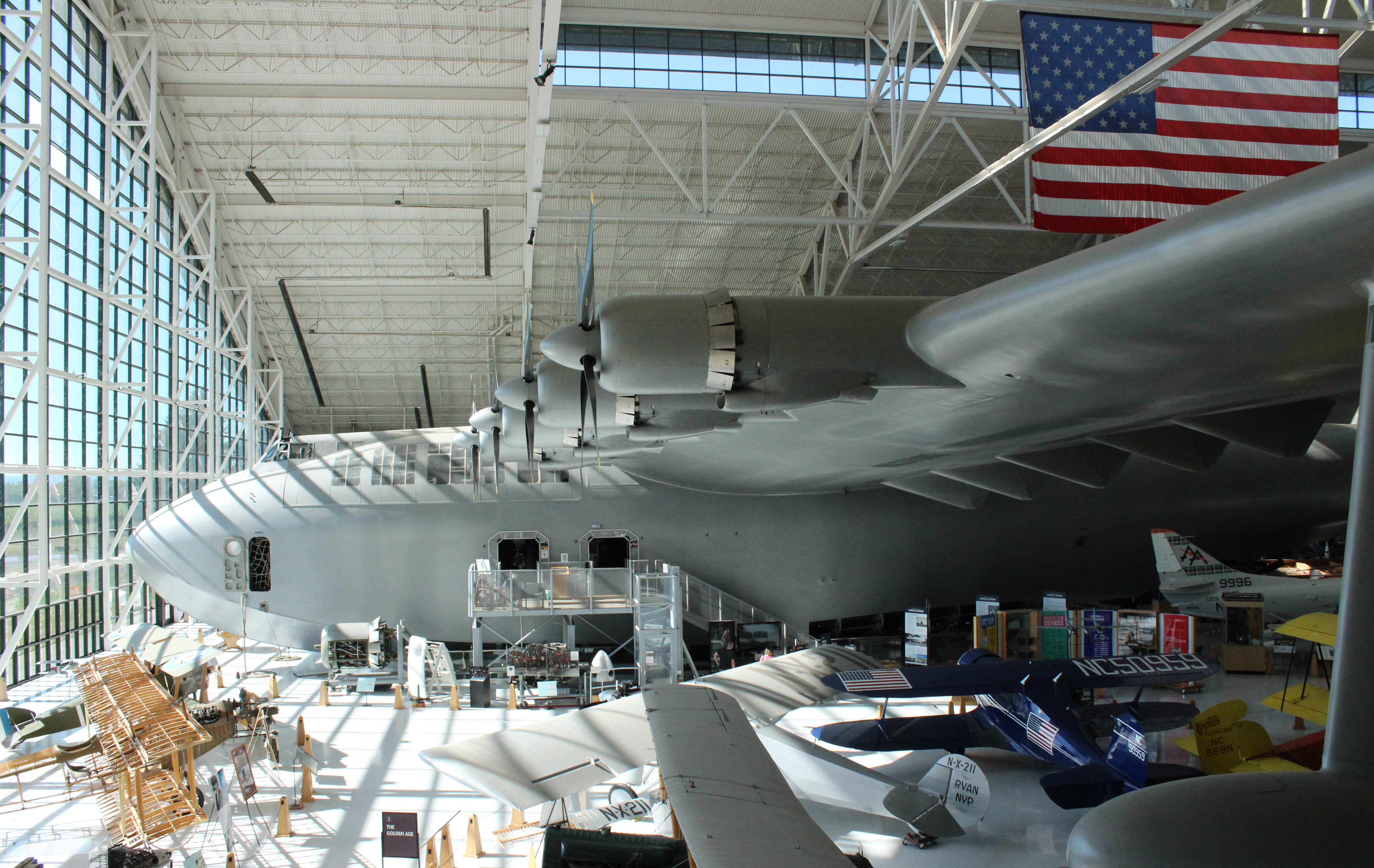 the Spruce Goose flying boat parked indoors t Evergreen Aviation Museum with other aircraft in foreground