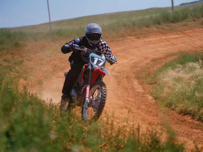 off road racing motorcycle trailing a dust cloud