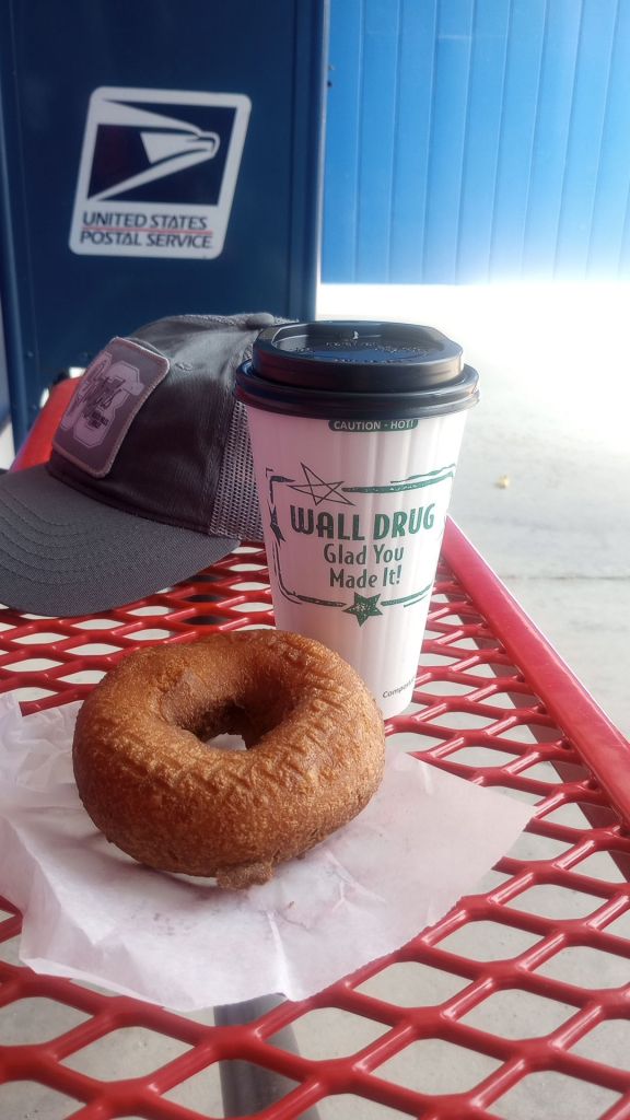 A coffee and donut from Wall Drug, with a USPS mailbox in the background