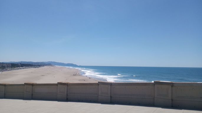 Ocean Beach in San Francisco, as viewed from the northern end looking south, daytime, under a cloudless sky