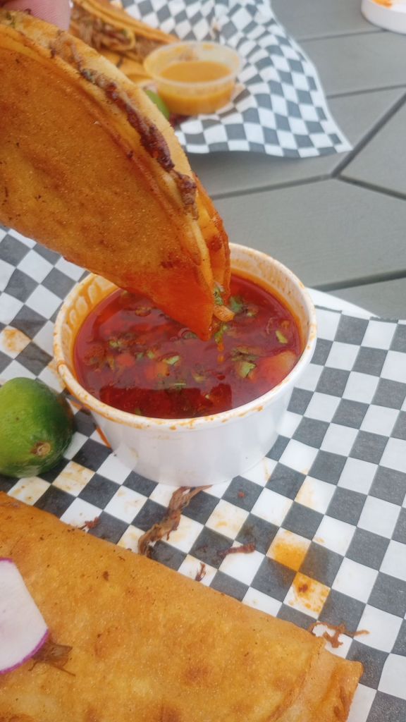 a birria taco dipped in consome